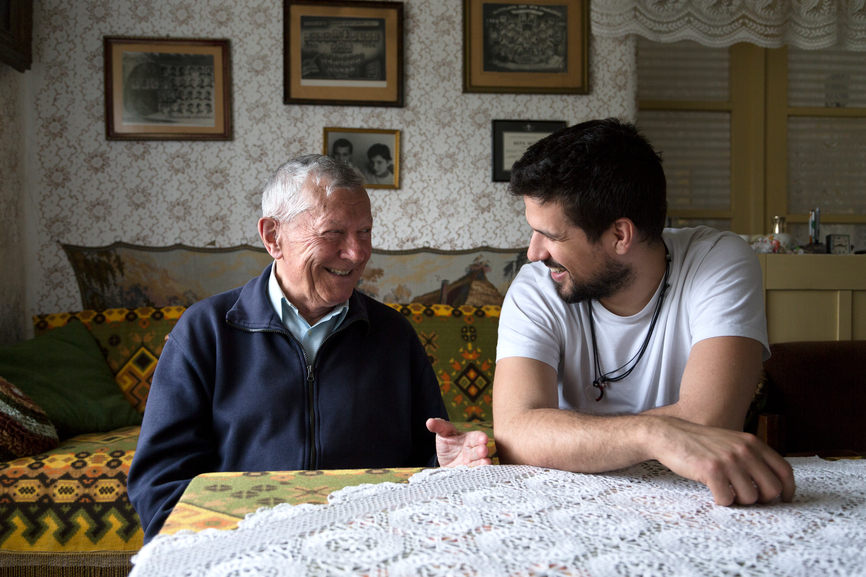An older man sharing a conversation with his live-in carer at home